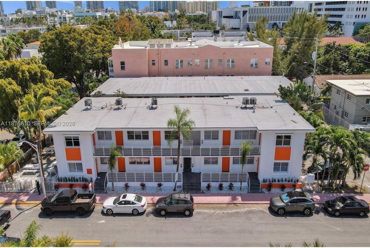 An aerial view of a two-story white apartment building with orange accents and parked cars — 1000 7th St, Miami Beach FL 33139, MIAMI BEACH, FL