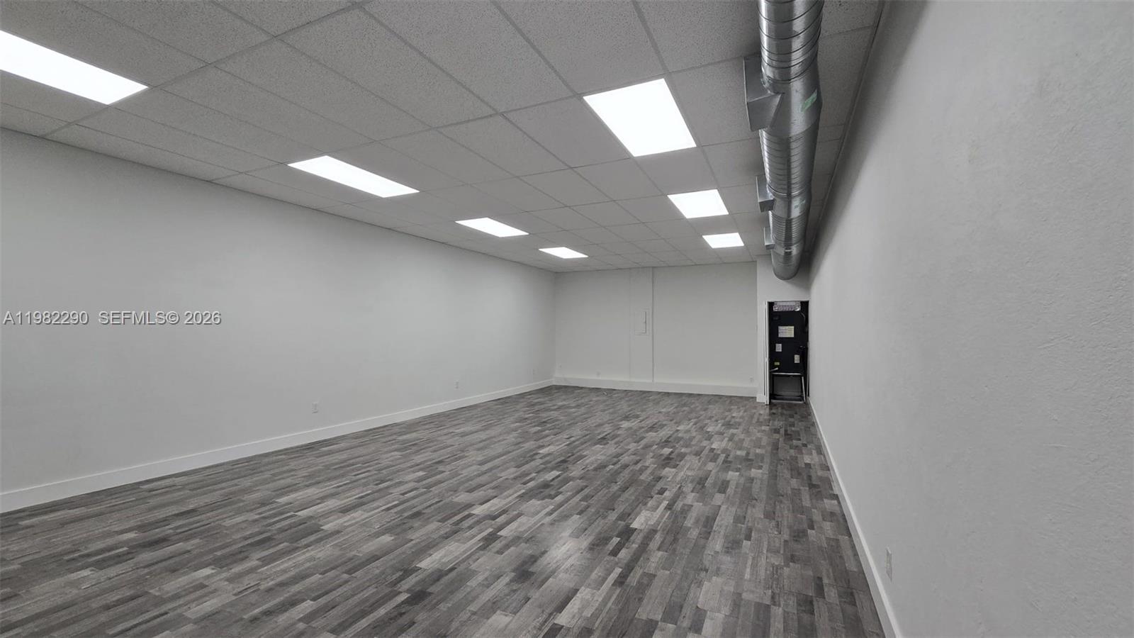 An empty room features white walls, a drop ceiling with recessed lighting, and gray flooring — 957 SW 122nd Ave # 957, Miami FL 33184, MIAMI, FL