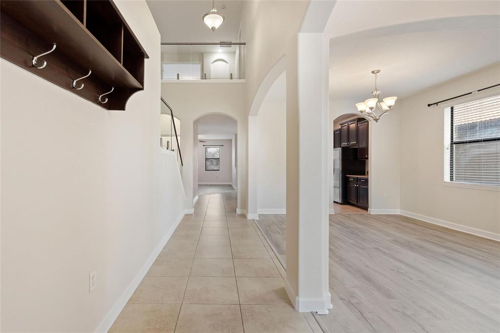 A tiled entryway leads to a dining area with wood-look flooring and an arched opening — 1315 MOSS CREEK LN, DAVENPORT, FL