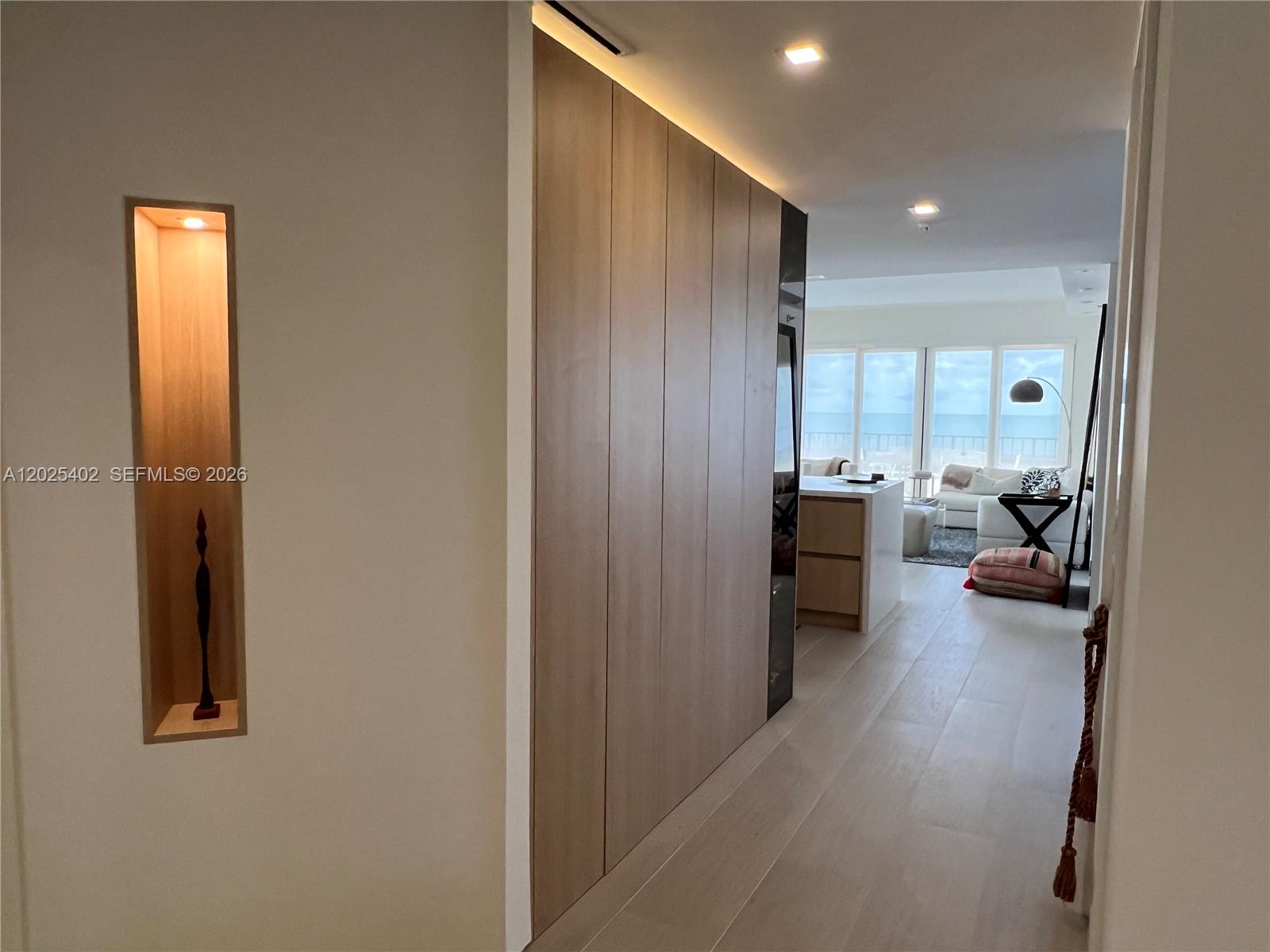A hallway with a recessed wall niche leads to an open-concept living area with ocean views — 201 Crandon Blvd # 642, Key Biscayne FL 33149, KEY BISCAYNE, FL