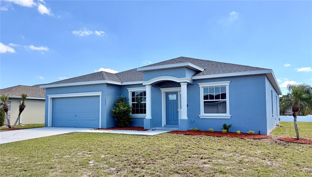 A blue, single-story house with a two-car garage and a covered front entryway — 1192 NORMANDY HEIGHTS CIRCLE, WINTER HAVEN, FL