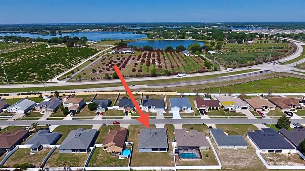 An aerial view shows a residential neighborhood with a red arrow pointing to a house — 1192 NORMANDY HEIGHTS CIRCLE, WINTER HAVEN, FL