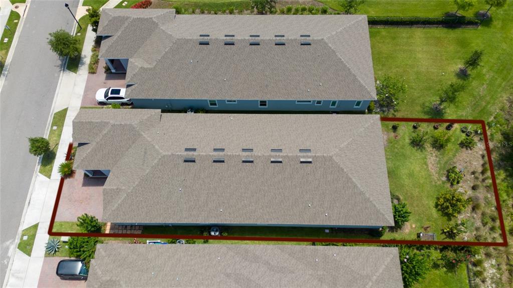 An aerial view shows a residential house with a fenced backyard and adjacent homes — 7687 BOWERY DRIVE, WINTER GARDEN, FL