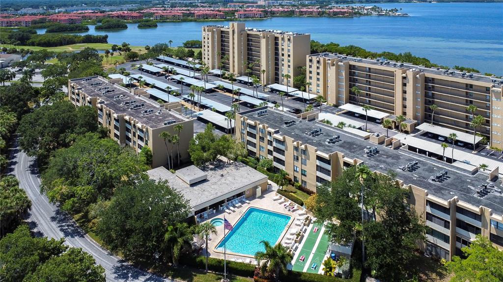 An aerial view shows multi-story apartment buildings, a swimming pool, and a parking lot — 2616 COVE CAY DRIVE UNIT 506, CLEARWATER, FL