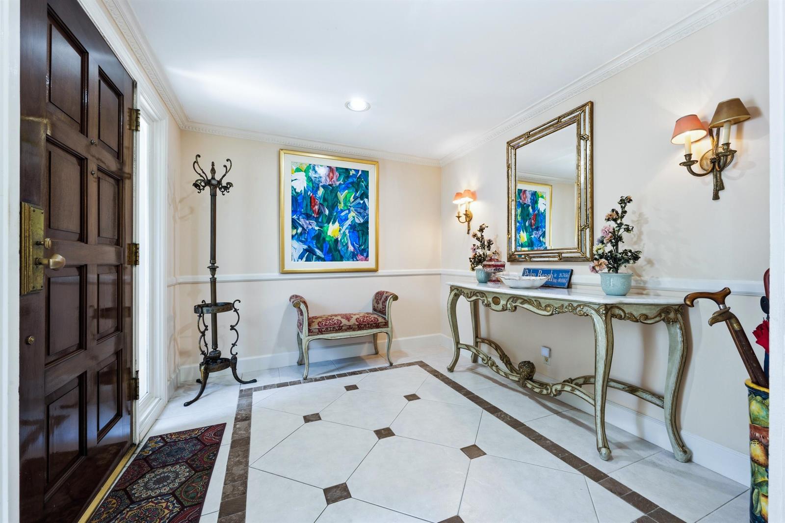 An entryway features a tiled floor, a console table with a mirror, and a small bench — 265 Fairview Road, Palm Beach FL 33480, PALM BEACH, FL