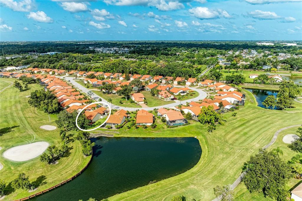 An aerial view shows a single-story house with a red tile roof and driveway — 4909 CLUBVIEW COURT E, BRADENTON, FL