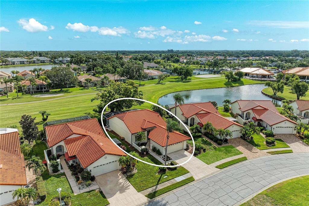 An aerial view shows a residential neighborhood with a circled house featuring a tile roof — 4909 CLUBVIEW COURT E, BRADENTON, FL