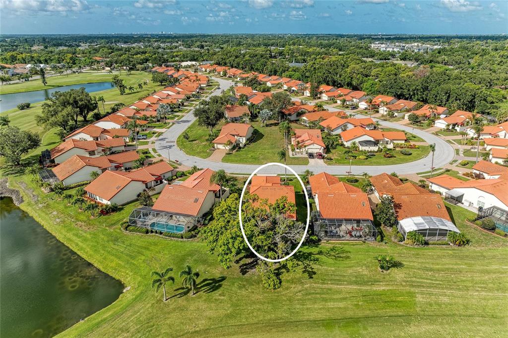 An aerial view shows several single-story houses with orange tile roofs near a golf course — 4909 CLUBVIEW COURT E, BRADENTON, FL
