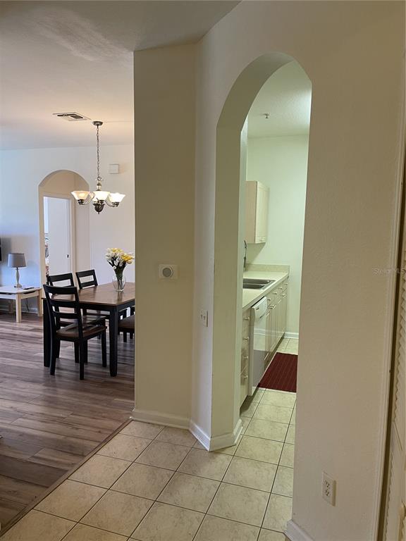 A tiled entryway leads to a kitchen through an archway, adjacent to a dining area — 2306 SILVER PALM DRIVE UNIT 105, KISSIMMEE, FL