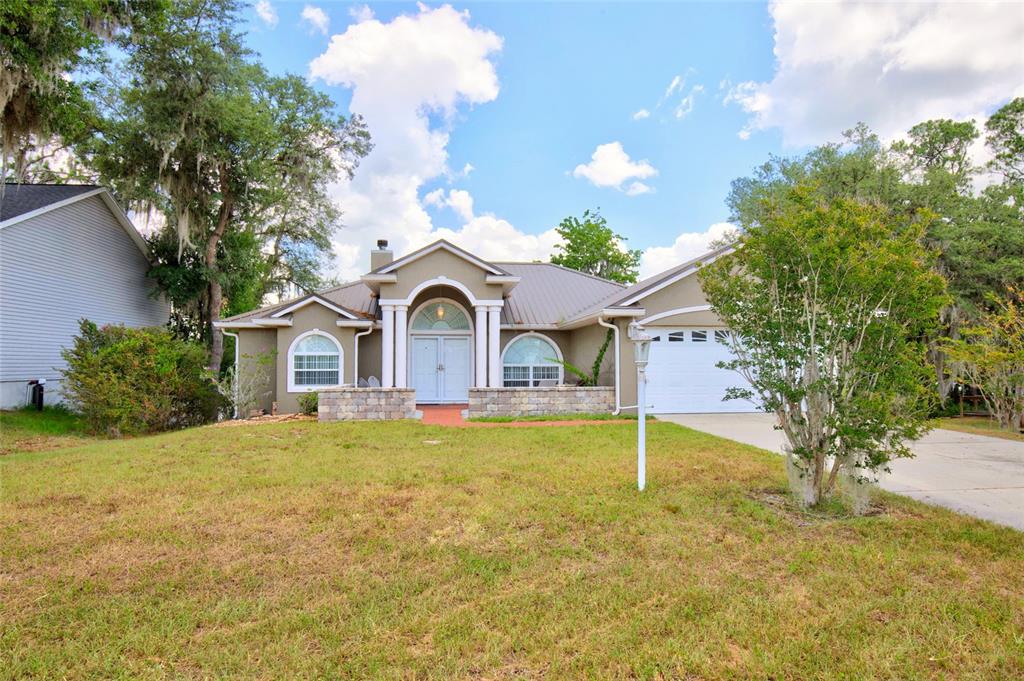 An aerial view shows a house with a red location pin beside a lake — 13059 NE 7TH LOOP, SILVER SPRINGS, FL