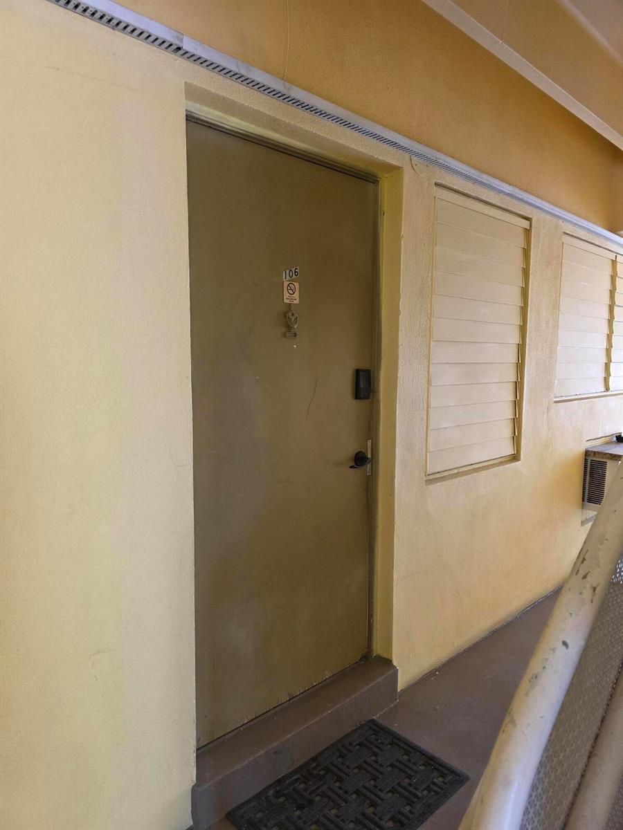 A beige exterior door with the number 106 is set in a yellow wall — 911 N Federal Highway # 106, FL 33460, FL