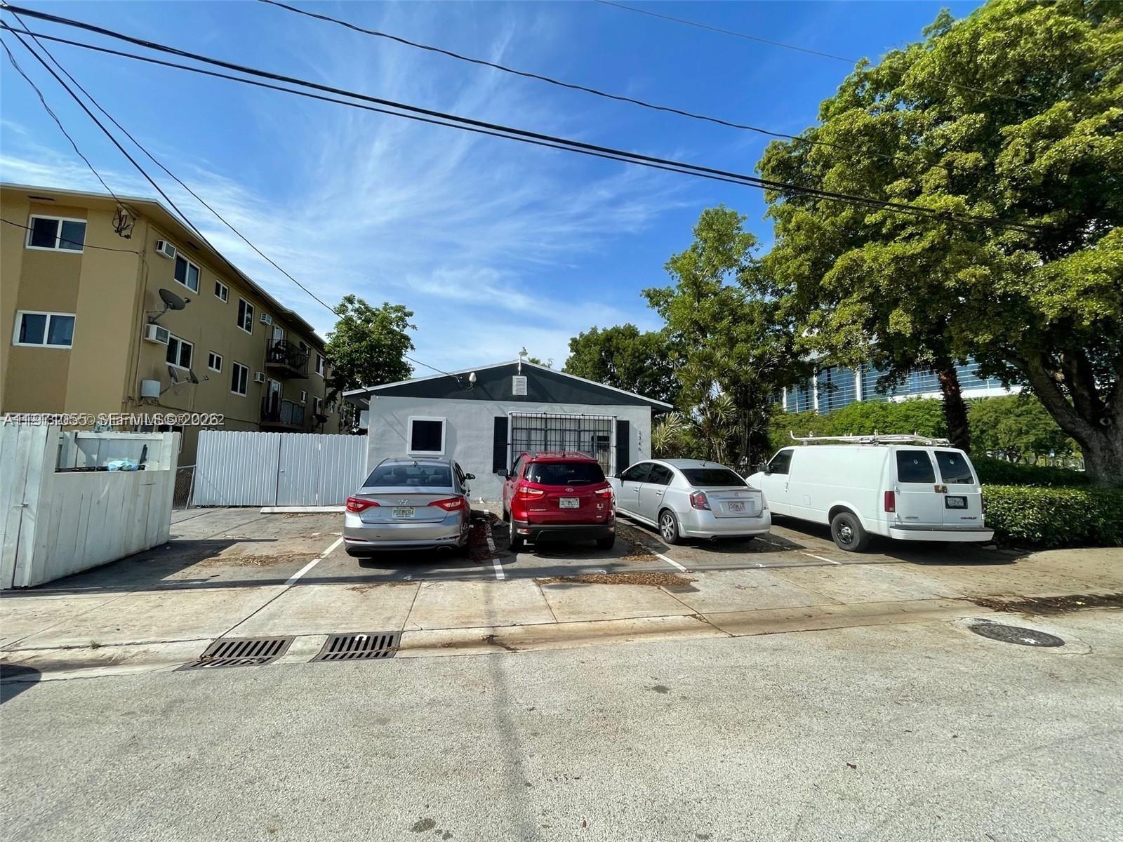 A single-story house with four parked vehicles in front sits beside a multi-story apartment building — 1346 NW 6th St # 4, Miami FL 33125, MIAMI, FL