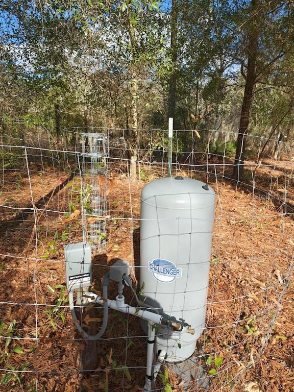 A well pump and pressure tank are enclosed by wire fencing in a wooded area — 13105 SW 91ST PLACE, DUNNELLON, FL
