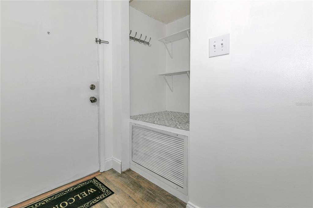 An entryway features a white door, a small storage nook with shelves, and a floor vent — 637 SILVER PASS UNIT B, OCALA, FL