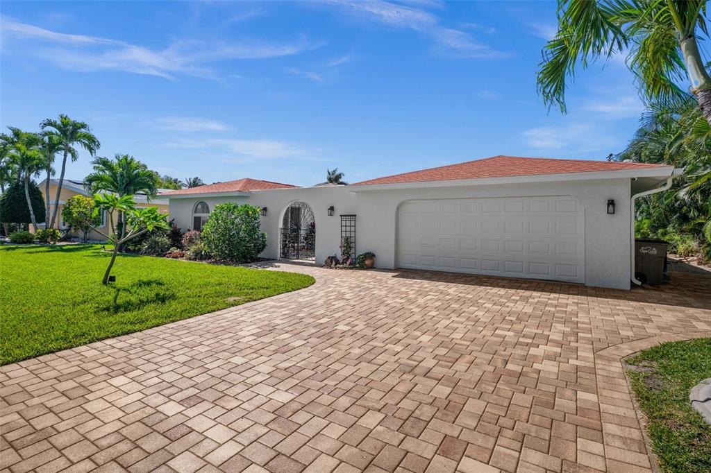 A single-story house with a white exterior, a red roof, and a paved driveway — 1432 VENETIAN COURT, CAPE CORAL, FL