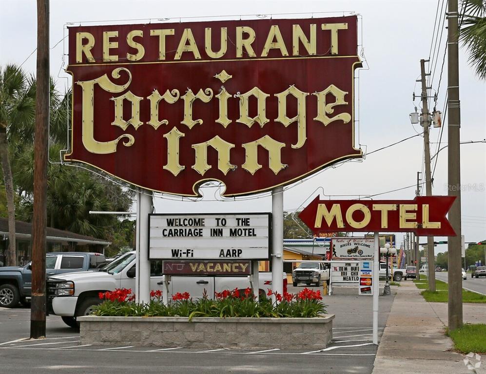 A large, weathered sign for the Carriage Inn restaurant and motel stands outdoors — 16872 SE HIGHWAY 19, CROSS CITY, FL