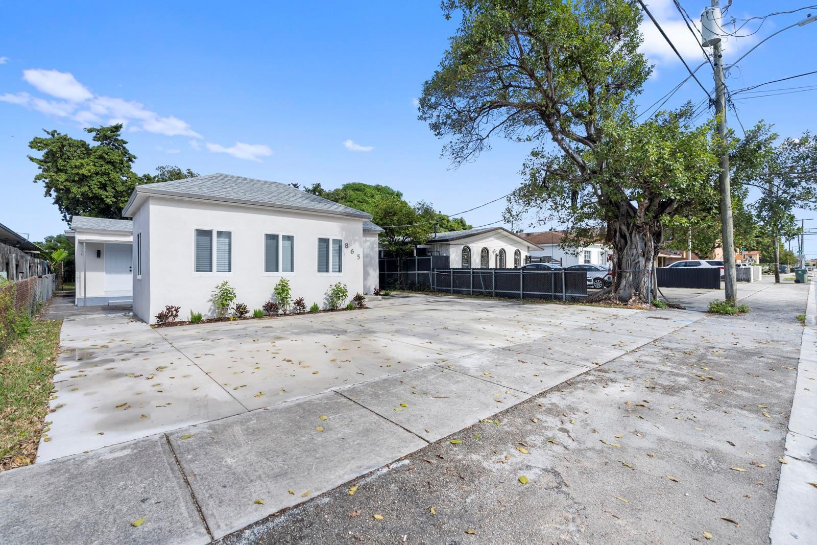 A white single-story house with a large concrete driveway and a mature tree — 865 SE 12th Street # A, Hialeah FL 33010, HIALEAH, FL