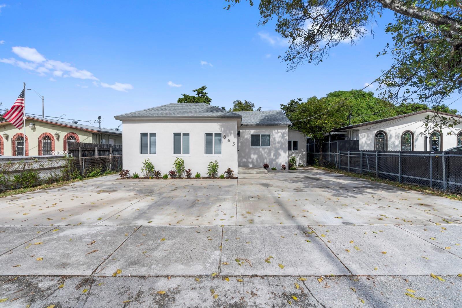 A white single-story house with a large concrete driveway and a front yard fence — 865 SE 12th Street # A, Hialeah FL 33010, HIALEAH, FL