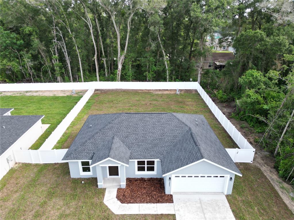 An aerial view of a single-story house with a gray roof and a fenced backyard — 3641 SE 140TH PLACE, SUMMERFIELD, FL