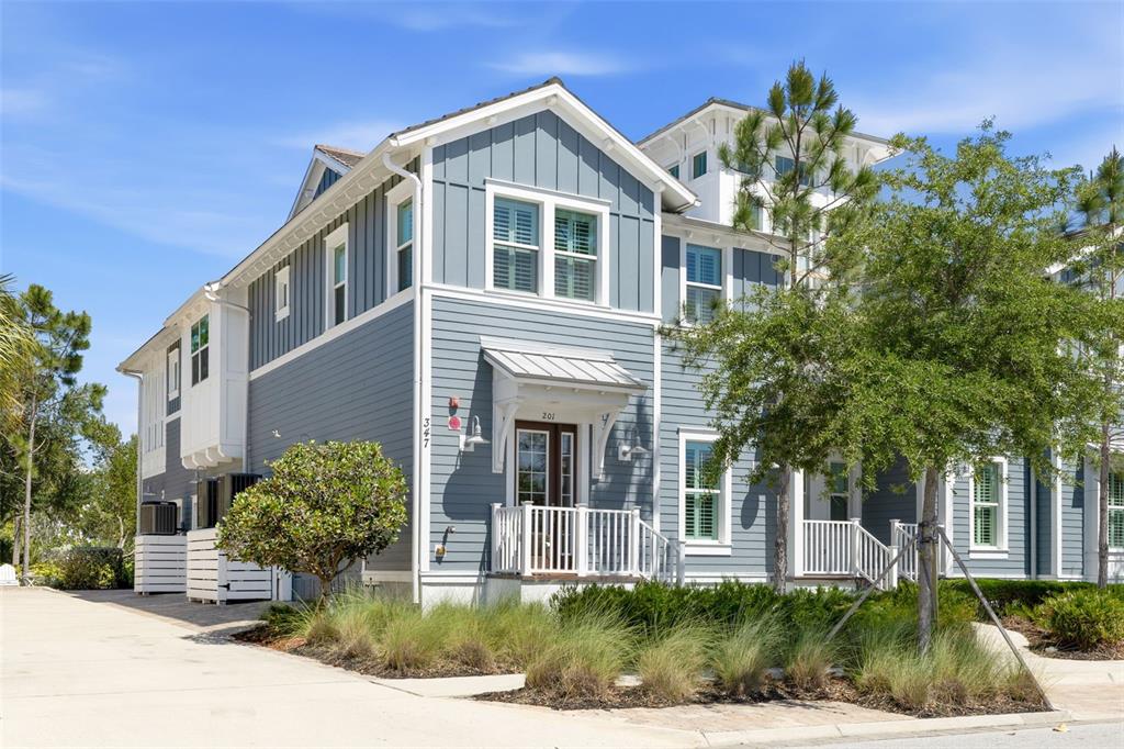 A two-story blue house with white trim and a small front porch under a roof — 347 COMPASS POINT DRIVE UNIT 201, BRADENTON, FL