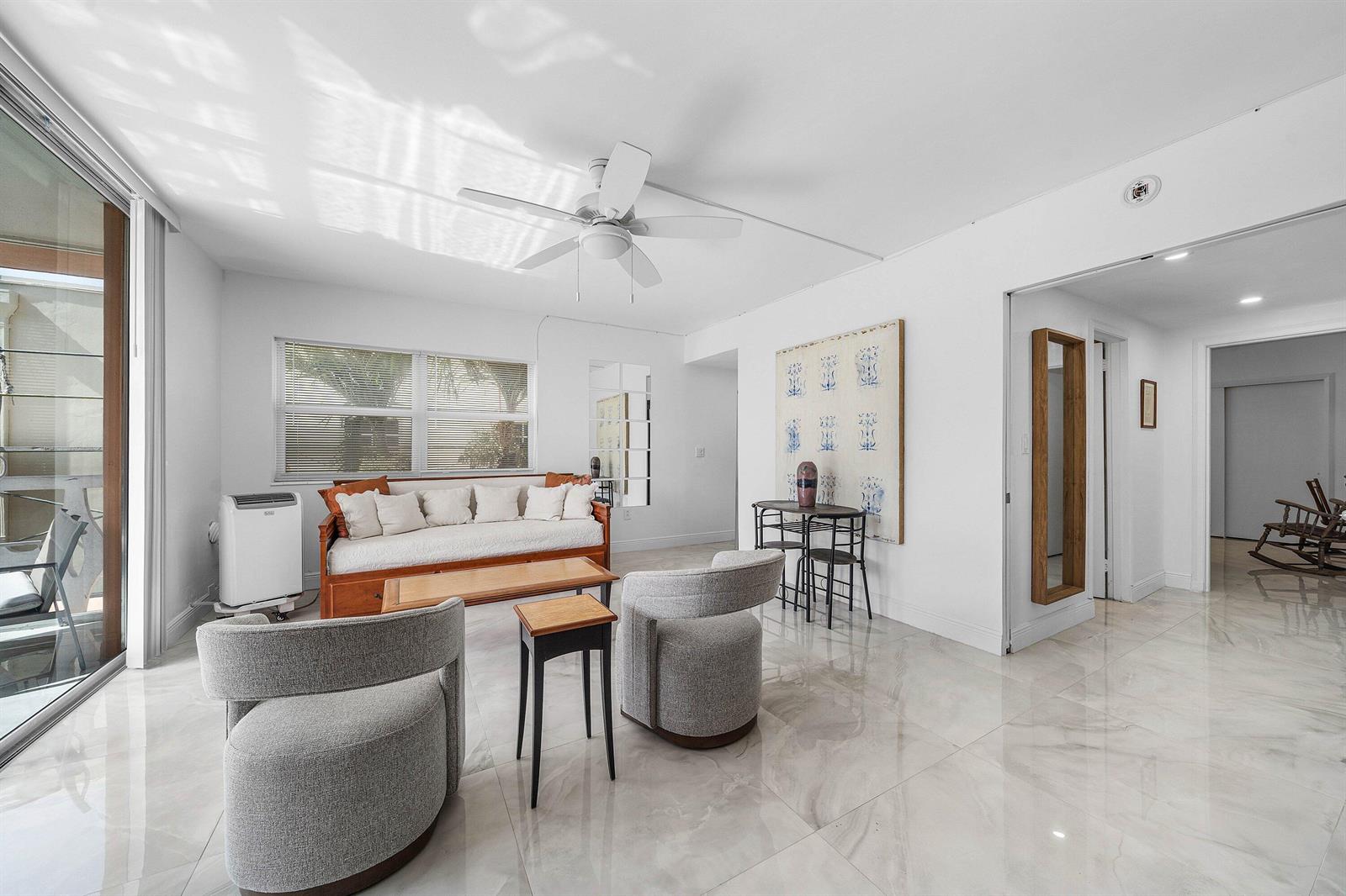 A bright living room features white tile floors, a daybed, two armchairs, and a ceiling fan — 15 S Golfview Road # 206, Lake Worth FL 33460, LAKE WORTH, FL