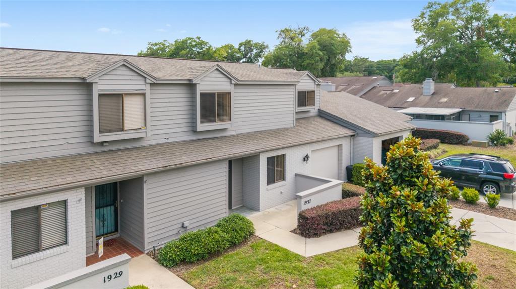 An exterior view of two adjacent gray townhouses with shingled roofs and small front lawns — 1927 SE 37TH COURT CIRCLE, OCALA, FL