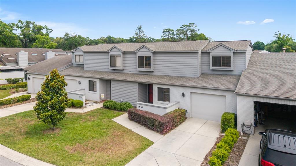 An exterior view of a two-story gray townhouse with a garage and a front lawn — 1927 SE 37TH COURT CIRCLE, OCALA, FL