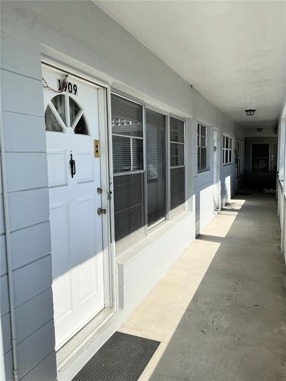 A white exterior door with the number 1909 sits along a concrete walkway — 4300 58TH STREET N UNIT 1909, KENNETH CITY, FL