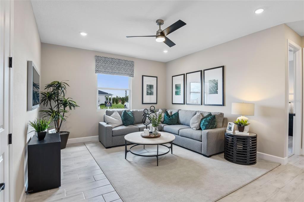 A living room features a grey sectional sofa, a round coffee table, and tile flooring — 6398 CLOVER STREET, LAKE HAMILTON, FL