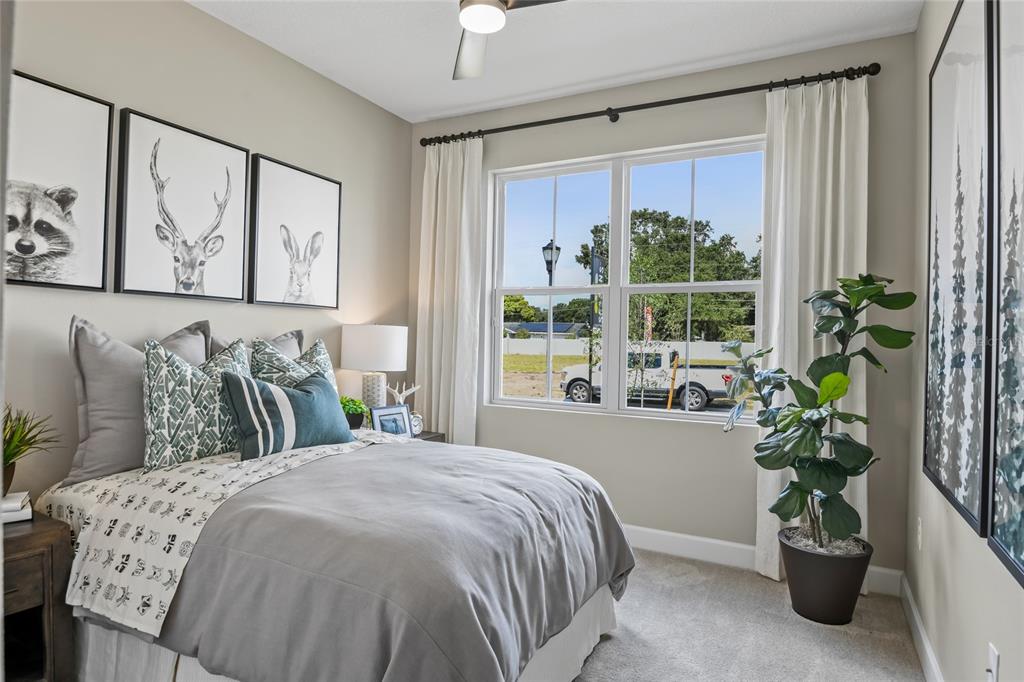 A bedroom features a bed with gray bedding, framed animal art, and a potted plant — 6398 CLOVER STREET, LAKE HAMILTON, FL