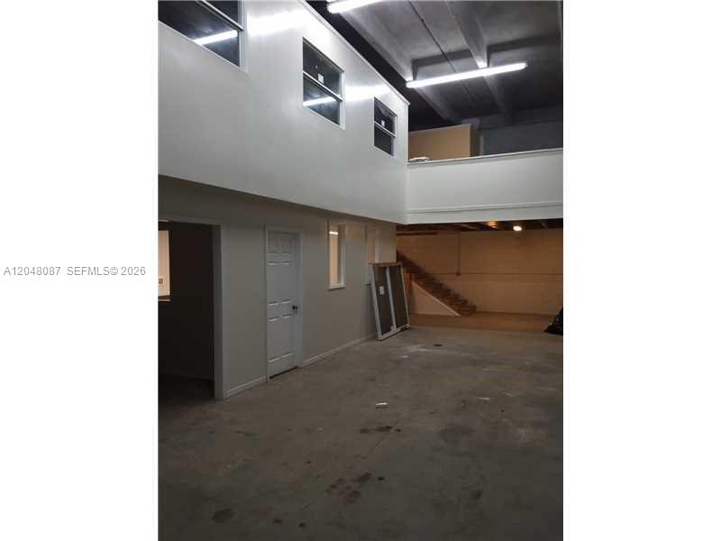 An interior view of a warehouse space with a mezzanine level and concrete flooring — 10680 NW 123rd St Rd # 104, Medley FL 33178, MEDLEY, FL