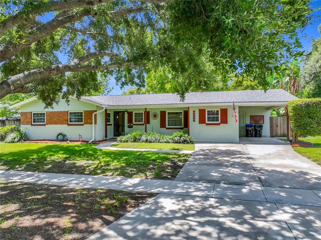 A single-story house with a light-colored exterior, brick accents, and an attached carport — 1534 LEEWAY AVENUE, ORLANDO, FL