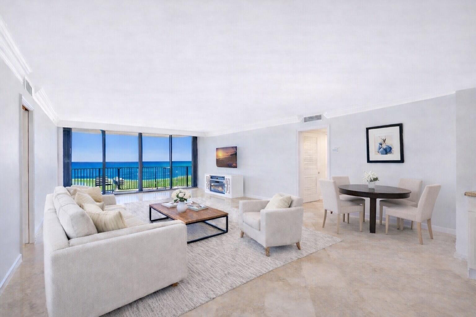 A bright living and dining area with ocean views, light tile floors, and neutral furniture — 400 Beach Road # 103, Tequesta FL 33469, TEQUESTA, FL