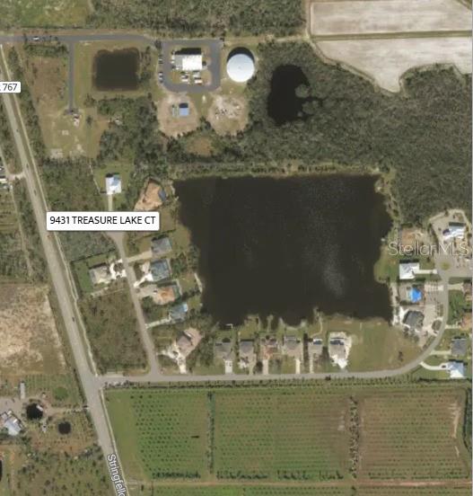 This aerial map shows a residential neighborhood surrounding a lake near a main road — 9431 TREASURE LAKE COURT, ST JAMES CITY, FL