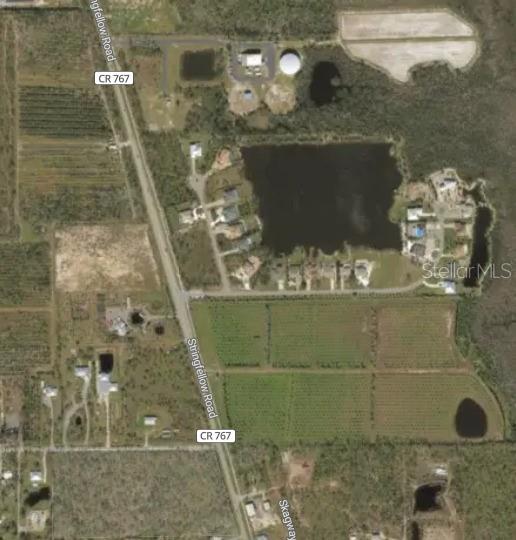 This is an aerial map view showing a road, residential homes, and agricultural land — 9431 TREASURE LAKE COURT, ST JAMES CITY, FL
