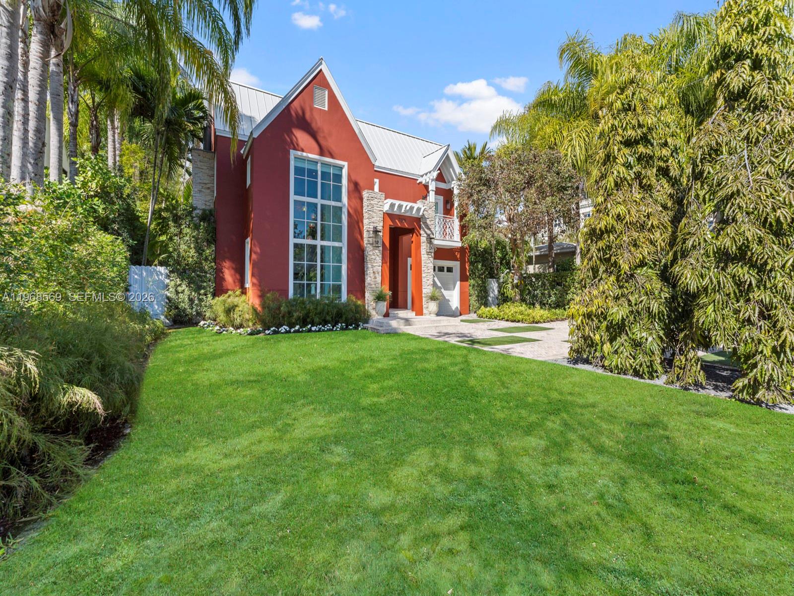 A two-story house with red stucco walls, stone accents, and a large window facade — 7218 SW 54th court, Miami FL 33143, MIAMI, FL