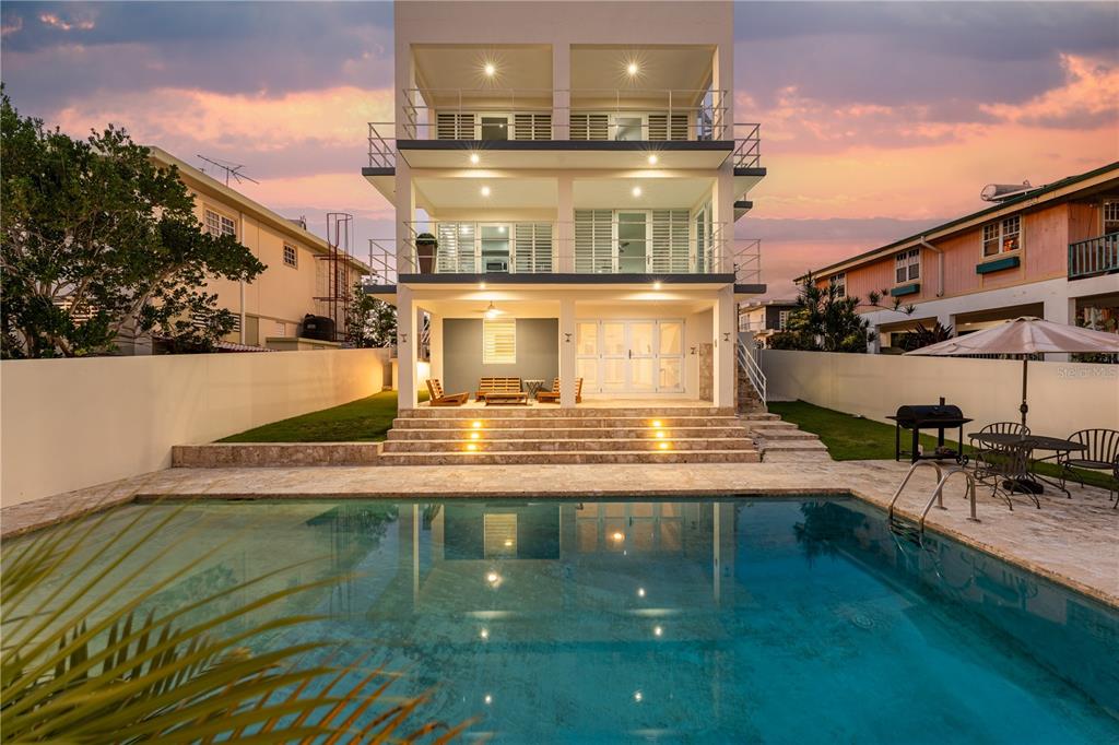 A three-story modern house with a swimming pool and patio area at sunset — SR 307 km 7.9 Boqueron VILLA NAUTICA, UNION ST, JOSE ST BEACH Lot # 2, BOQUERON, PR