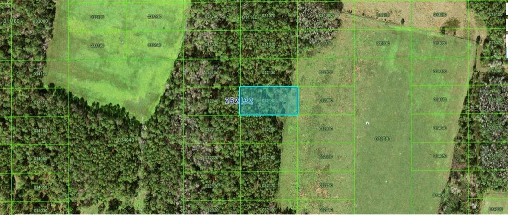 This is an aerial map showing a highlighted rectangular parcel of land surrounded by wooded areas — COMMONWEALTH AVE N, POLK CITY, FL