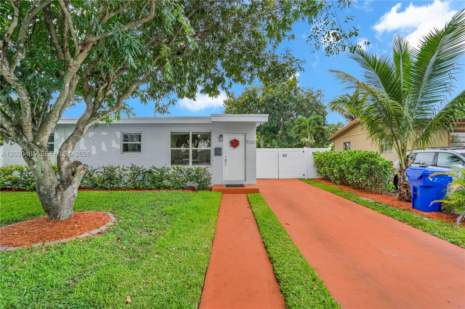 A single-story house with a gray exterior, a red driveway, and a front lawn — 7220 Arthur St, Hollywood FL 33024, HOLLYWOOD, FL