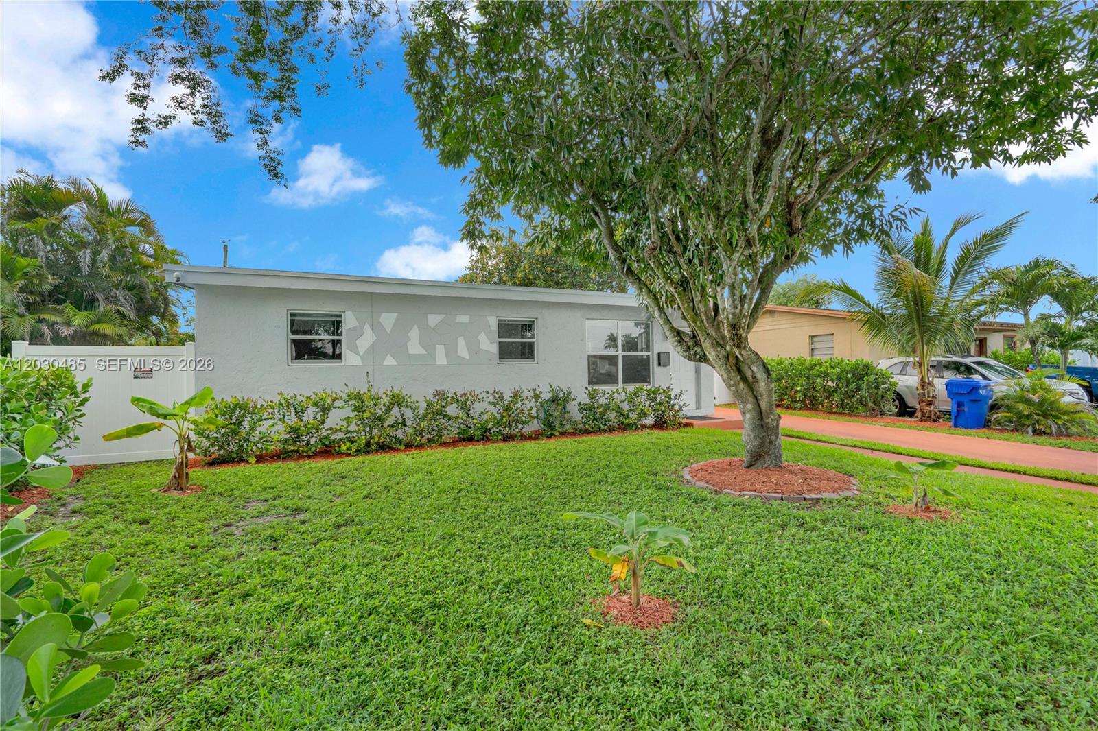 A single-story white house features a front lawn, a large tree, and a paved driveway — 7220 Arthur St, Hollywood FL 33024, HOLLYWOOD, FL