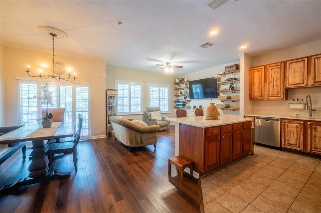 An open-concept kitchen and dining area features wood flooring, a center island, and wooden cabinetry — 815 S FORT HARRISON AVENUE, CLEARWATER, FL