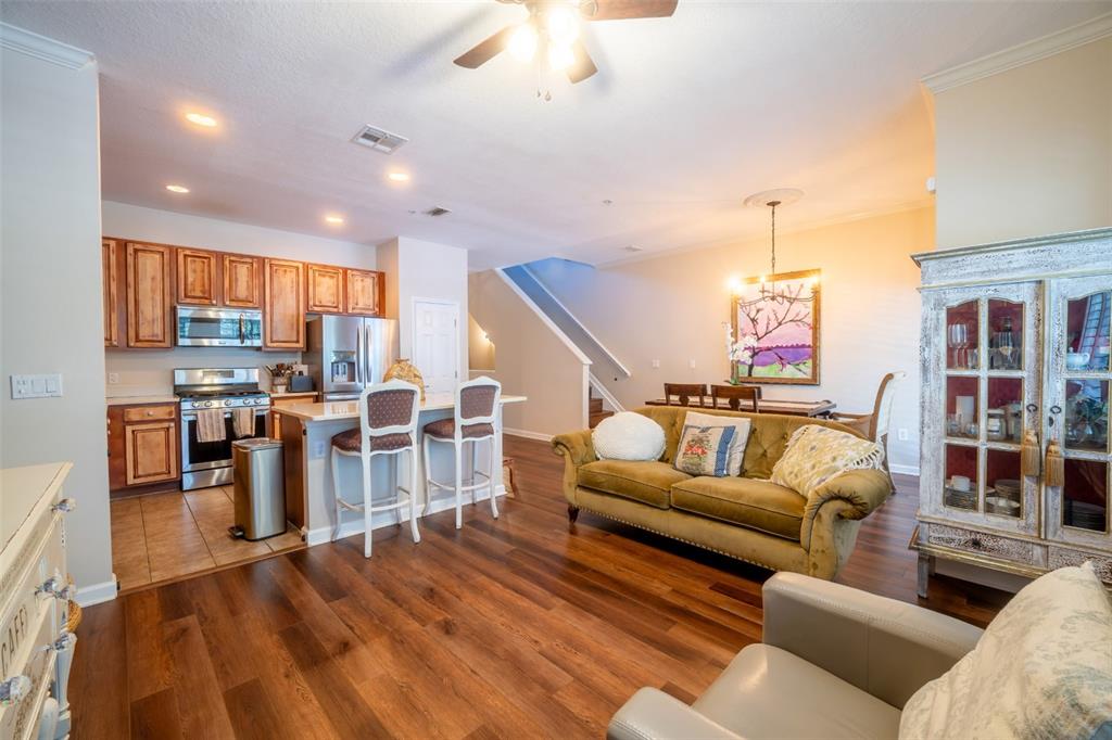 An open-concept living and dining area features wood flooring, a kitchen island, and a sofa — 815 S FORT HARRISON AVENUE, CLEARWATER, FL