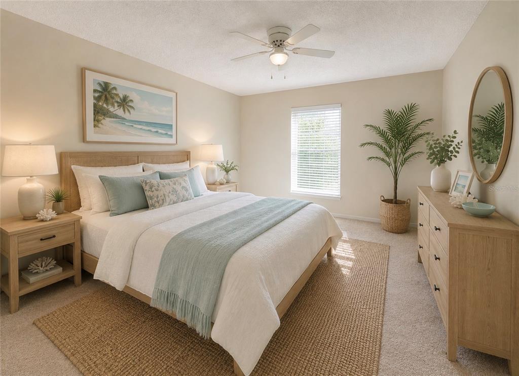 A bedroom features a bed with light blue bedding, a wooden dresser, and a ceiling fan — 1655 S HIGHLAND AVENUE UNIT D238, CLEARWATER, FL
