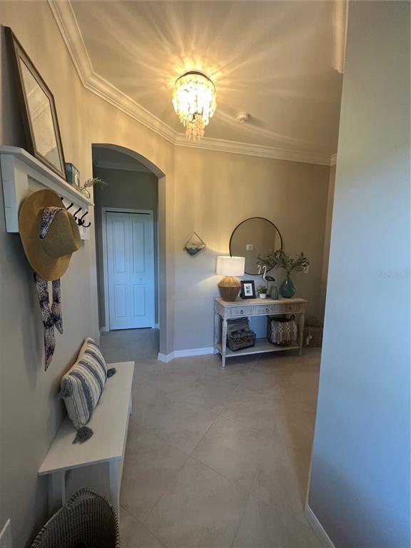 An entryway features a white bench, a console table with a mirror, and a chandelier — 2040 MACKEREL STREET, PORT CHARLOTTE, FL