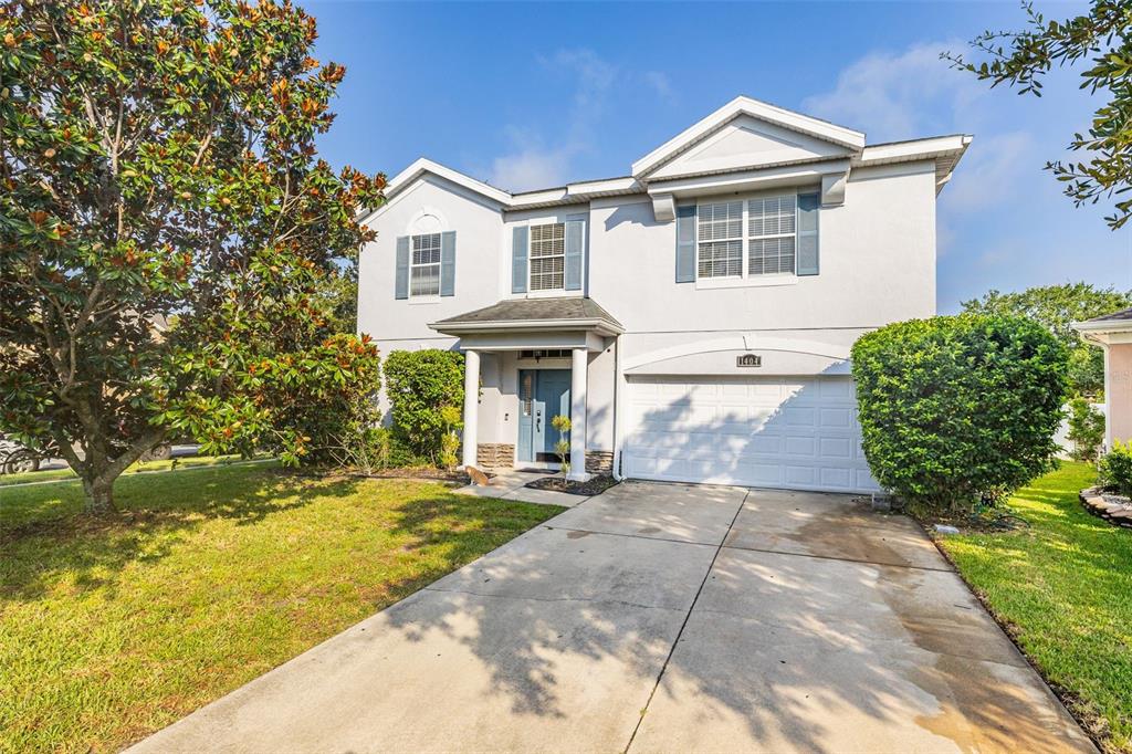 A two-story house with a white stucco exterior, a garage, and a concrete driveway — 1404 SWAINSON COURT, ORLANDO, FL