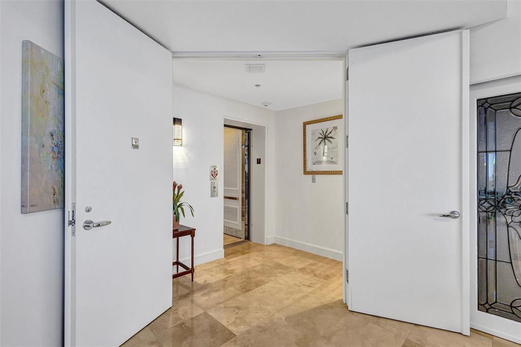 A tiled foyer features double white doors opening to an elevator and a framed print — 3060 GRAND BAY BOULEVARD UNIT 174, LONGBOAT KEY, FL