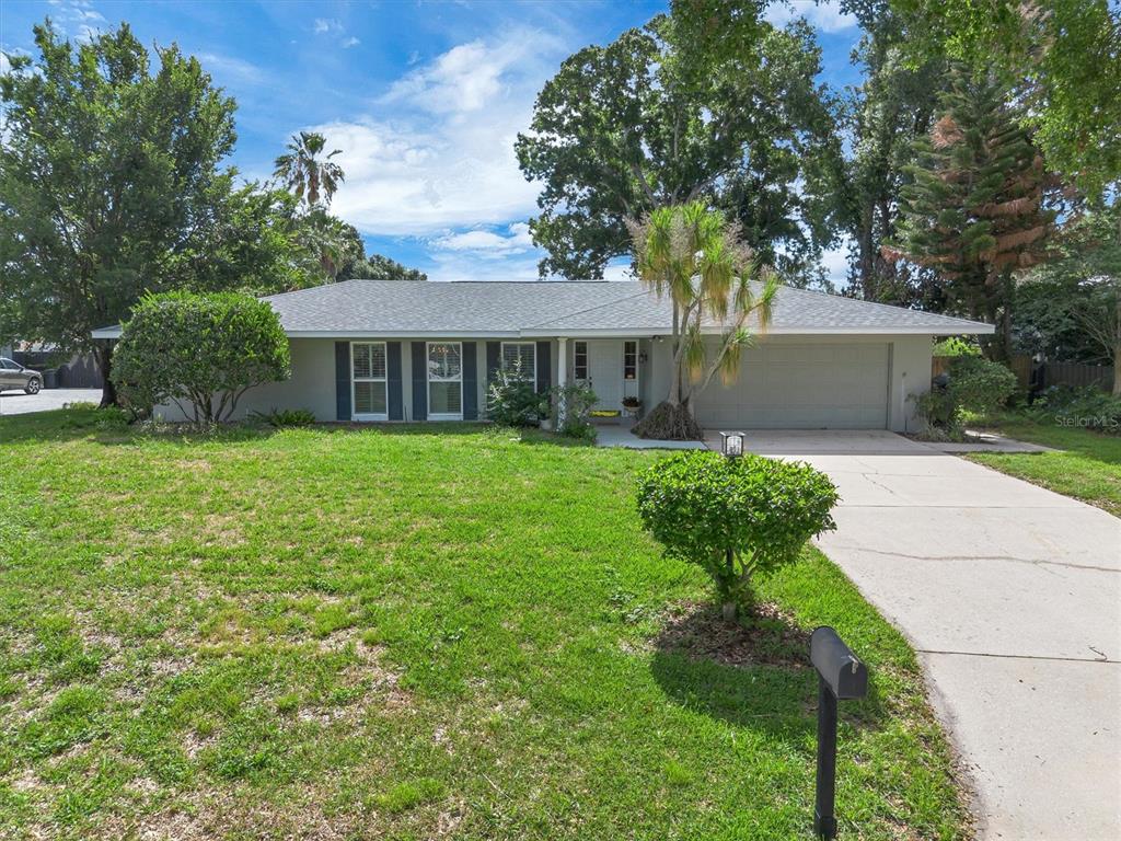 A single-story house with a gray exterior, a two-car garage, and a front lawn — 136 LAKE MARIAM ROAD SE, WINTER HAVEN, FL