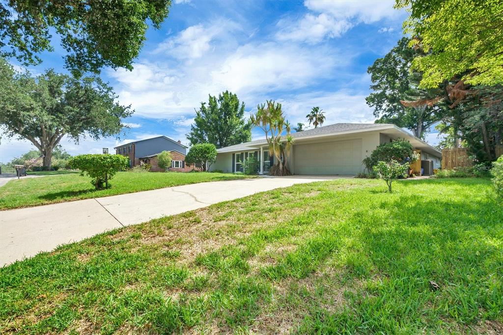 A single-story house with a two-car garage and a concrete driveway sits on a lawn — 136 LAKE MARIAM ROAD SE, WINTER HAVEN, FL