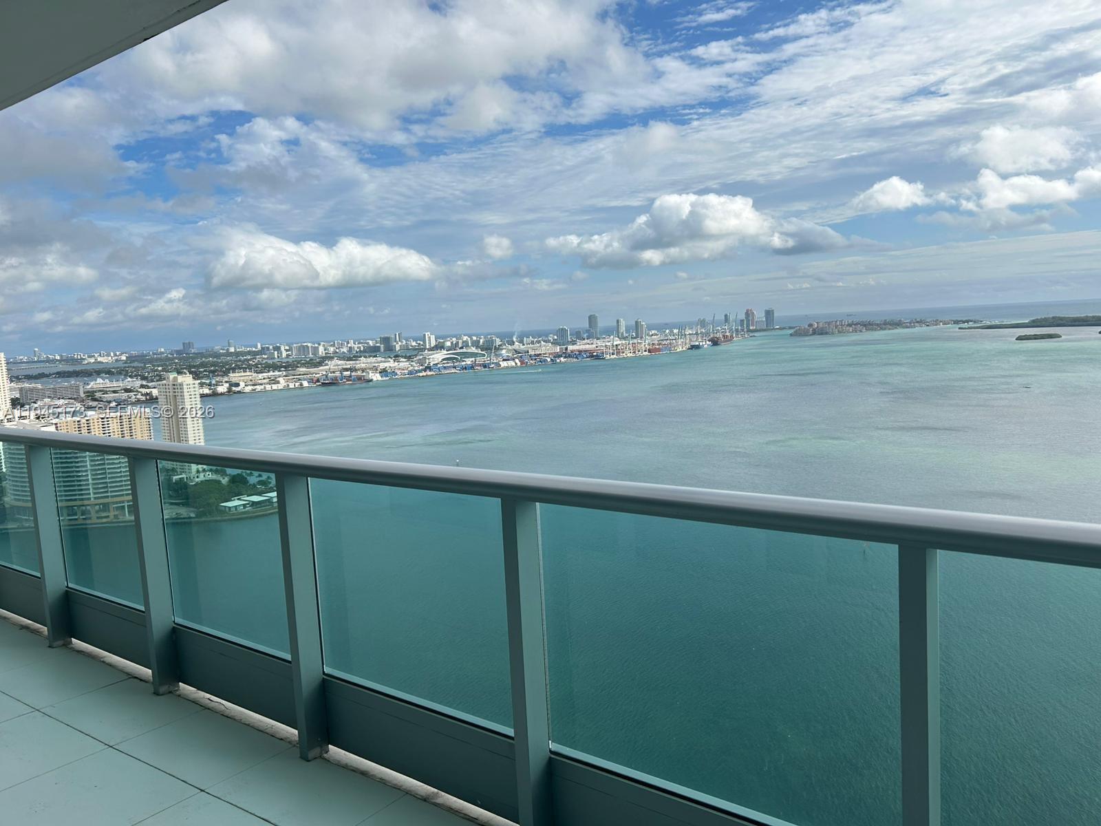 A high-rise balcony overlooks a large bay with a city skyline in the distance — 1331 Brickell Bay Dr # 4107, Miami FL 33131, MIAMI, FL