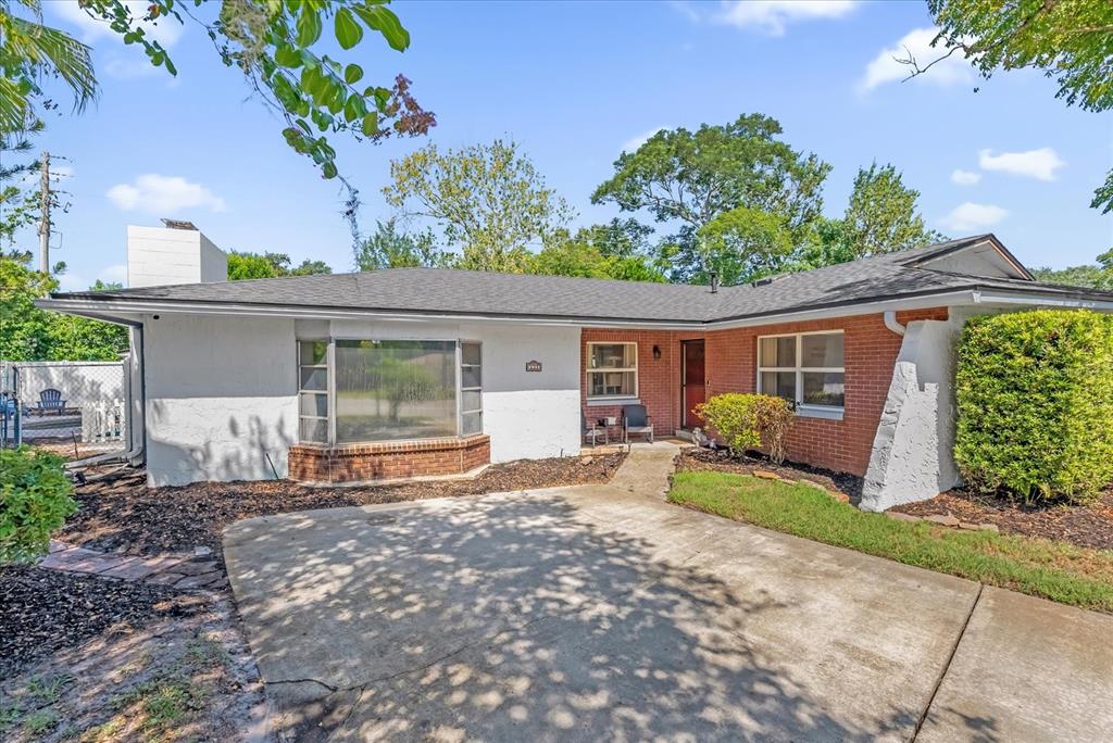 A single-story house features a white painted exterior, a brick section, and a concrete driveway — 623 SWALLOW DRIVE, CASSELBERRY, FL